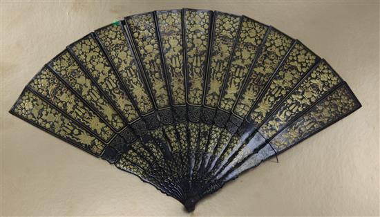 A large Chinese export gilt decorated black lacquer fan, mid 19th century, length 31cm, perspex case